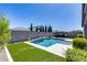 Sparkling pool with waterfall feature, artificial grass, and lounge chairs for ultimate relaxation at 13171 W Redstone Dr, Peoria, AZ 85383