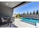 Inviting covered patio overlooks a sparkling pool with serene water feature and lush landscaping at 13171 W Redstone Dr, Peoria, AZ 85383