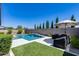 Inviting backyard with sparkling pool, water feature, turf, and shaded lounge area for relaxation at 13171 W Redstone Dr, Peoria, AZ 85383