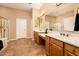 Bright bathroom showcasing double sink vanity, glass shower enclosure, tile flooring, and linen closet at 13444 W Cabrillo Dr, Sun City West, AZ 85375