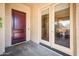 A warm and inviting foyer featuring a beautiful wood door and convenient access to the outdoors at 13444 W Cabrillo Dr, Sun City West, AZ 85375