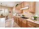 Charming kitchen featuring wood cabinets, neutral countertops, tile floors, and stainless steel appliances at 13444 W Cabrillo Dr, Sun City West, AZ 85375