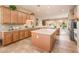 Spacious open kitchen features wooden cabinetry, tile flooring, a center island, and stainless steel appliances at 13444 W Cabrillo Dr, Sun City West, AZ 85375