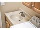 Laundry sink with a silver faucet, next to a washing machine at 13444 W Cabrillo Dr, Sun City West, AZ 85375