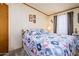 Cozy bedroom featuring a large bed with patterned bedding, carpet flooring, and natural light from the window at 1640 E Augusta Ave, Chandler, AZ 85249