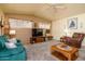 Bright living room featuring cozy seating, entertainment center, ceiling fan, and natural light at 1640 E Augusta Ave, Chandler, AZ 85249