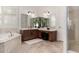 Bright bathroom featuring double vanity, soaking tub, walk-in shower and neutral tile flooring at 1804 W Magdalena Ln, Phoenix, AZ 85041