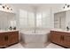 Bright bathroom featuring a soaking tub, plantation shutters and double vanity at 1804 W Magdalena Ln, Phoenix, AZ 85041