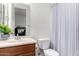 Bright bathroom featuring a vanity and toilet with patterned shower curtain at 1804 W Magdalena Ln, Phoenix, AZ 85041