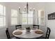Cozy dining area features a round wood table, modern chandelier, and shuttered windows at 1804 W Magdalena Ln, Phoenix, AZ 85041