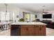 Kitchen island with a sink and dishwasher boasts seating, a breakfast nook, and access to the living room at 1804 W Magdalena Ln, Phoenix, AZ 85041