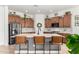 Kitchen boasts wood cabinets, quartz counters, stainless appliances, and kitchen island with seating at 1804 W Magdalena Ln, Phoenix, AZ 85041
