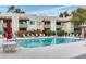 Relaxing community pool with lounge chairs, shade umbrella, and building in the background at 1825 W Ray Rd # 1134, Chandler, AZ 85224