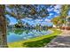 Scenic lake view reflects the sky and surrounding homes; framed by a tree, and lush green lawn at 1825 W Ray Rd # 1134, Chandler, AZ 85224