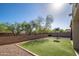 Landscaped backyard with a basketball hoop and artificial turf offers space for outdoor fun at 18401 W Westfall Way, Surprise, AZ 85374