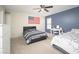Bright bedroom featuring two beds, a ceiling fan, and a desk area at 18401 W Westfall Way, Surprise, AZ 85374