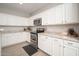 Close-up of the kitchen featuring white cabinets, granite countertops, and stainless steel appliances at 18401 W Westfall Way, Surprise, AZ 85374