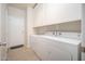 A modern, bright laundry room with a washer and dryer and ample storage at 18401 W Westfall Way, Surprise, AZ 85374