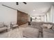 Bright living room features a stylish sofa, barn door and neutral decor, creating a comfortable atmosphere at 18401 W Westfall Way, Surprise, AZ 85374