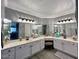 Bathroom boasts double sinks, an array of mirrors, and a seated vanity at 19014 N 91St Dr, Peoria, AZ 85382