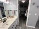 Bright bathroom with double vanity, white marble countertop, and open walk-in closet at 19014 N 91St Dr, Peoria, AZ 85382