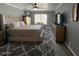 Comfortable bedroom boasts large windows, soft carpeting, and a ceiling fan at 19014 N 91St Dr, Peoria, AZ 85382