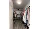 Walk-in closet with grey wood-look flooring and shelving and storage for clothing at 19014 N 91St Dr, Peoria, AZ 85382