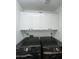 Laundry room with overhead cabinets and modern black washer and dryer units at 19014 N 91St Dr, Peoria, AZ 85382