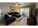 Bright living room featuring a ceiling fan, TV, and sliding glass doors at 19014 N 91St Dr, Peoria, AZ 85382