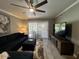 Bright living room featuring a ceiling fan, TV, and sliding glass doors at 19014 N 91St Dr, Peoria, AZ 85382