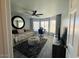 Bright living room with a ceiling fan, daybed, round mirror, and bay windows with a work space at 19014 N 91St Dr, Peoria, AZ 85382