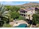 Aerial view of a beautiful home with a swimming pool, lush landscaping, and mountain views in the distance at 1922 E Everett Dr, Phoenix, AZ 85022
