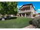 Expansive backyard featuring artificial turf, mature trees, and a covered patio with comfortable seating at 1922 E Everett Dr, Phoenix, AZ 85022