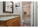 Bathroom with a single sink, granite counters, wood cabinets, and a view of the toilet and shower at 1922 E Everett Dr, Phoenix, AZ 85022