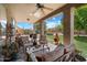 Relaxing covered patio featuring comfortable seating, a ceiling fan, and a view of the lush backyard and pool area at 1922 E Everett Dr, Phoenix, AZ 85022