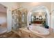 Luxurious main bathroom with glass shower, jacuzzi tub and arched mirror reflecting the double vanity at 1922 E Everett Dr, Phoenix, AZ 85022