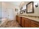 Spacious main bathroom features double sinks with granite counters and tiled floors near a door to the toilet room at 1922 E Everett Dr, Phoenix, AZ 85022