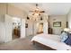 Spacious main bedroom with high ceilings, fan, ensuite bath, and decor shelves on the walls at 1922 E Everett Dr, Phoenix, AZ 85022