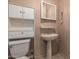 Bright bathroom featuring open shelving, a pedestal sink and mirror at 19251 N 17Th Dr, Phoenix, AZ 85027