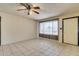 Inviting living room featuring neutral tile floors, ceiling fan, and ample natural light at 19251 N 17Th Dr, Phoenix, AZ 85027