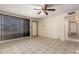 Bright living room featuring neutral tile floors, ceiling fan, and large windows, ready for personalization at 19251 N 17Th Dr, Phoenix, AZ 85027