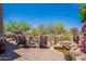Expansive backyard with seating around a fire pit and a tranquil rock waterfall and pond at 19475 N Grayhawk Dr # 1039, Scottsdale, AZ 85255
