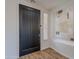 Elegant foyer showcasing a modern black door, wood flooring, and artwork at 19475 N Grayhawk Dr # 1039, Scottsdale, AZ 85255