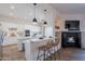 Bright, open kitchen with white cabinets, island seating, and a cozy fireplace, creating an inviting atmosphere at 19475 N Grayhawk Dr # 1039, Scottsdale, AZ 85255