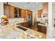 Spacious kitchen with granite counters, stainless appliances, hardwood floors, and wooden cabinetry at 19475 N Grayhawk Dr # 1115, Scottsdale, AZ 85255