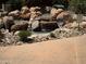 Relaxing water feature with stacked rocks and a small waterfall in a meticulously landscaped area at 19475 N Grayhawk Dr # 1115, Scottsdale, AZ 85255