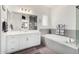 Bright bathroom featuring a large mirror, double sinks, bathtub, and walk-in shower at 2052 E Scorpio Pl, Chandler, AZ 85249