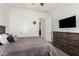 Bedroom with wood dresser and TV, featuring neutral tones and natural light at 2052 E Scorpio Pl, Chandler, AZ 85249