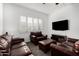 Comfortable living room featuring plush leather furniture, a large window, and modern entertainment center at 2052 E Scorpio Pl, Chandler, AZ 85249