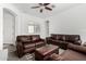 Spacious living room showcasing leather sofas, a ceiling fan, and an arched entryway at 2052 E Scorpio Pl, Chandler, AZ 85249